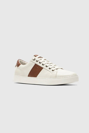 The Rodd & Gunn Endeavour Cruise Sneaker is a comfortable leather shoe with brown heel and side accents, white laces, and a white sole, shown on a plain light grey background.