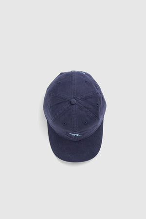 The Rodd & Gunn Gunn Cap, a navy blue cotton twill cap with a curved brim, is shown from above against a plain light gray background.