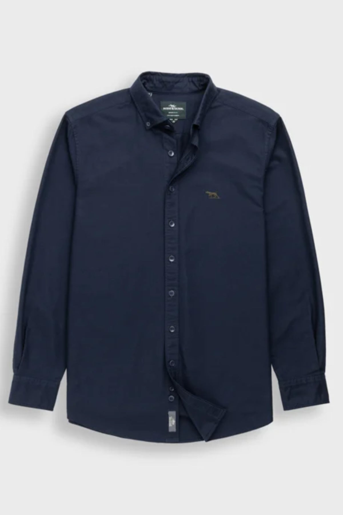 Rodd & Gunn Gunn Oxford Sports Fit Shirt in dark navy with long sleeves, collar, buttoned cuffs, and a small embroidered animal logo on the left chest. Made of 100% cotton and shown laid flat on a light gray background.