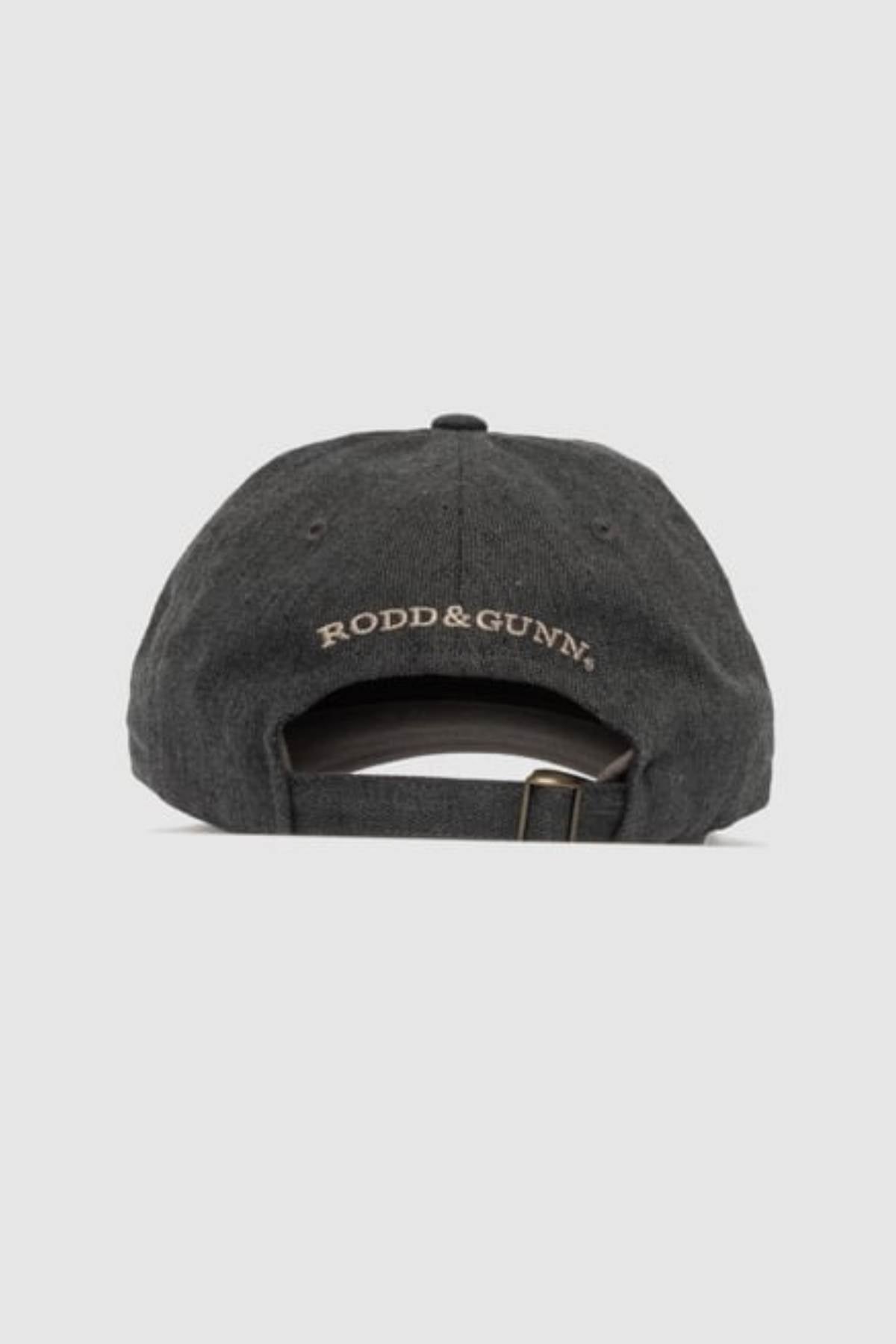 The Rodd & Gunn Signature Cap is a dark gray cotton twill cap shown from the back, with "RODD & GUNN" embroidered above an adjustable strap and metal buckle. The background is plain light gray.