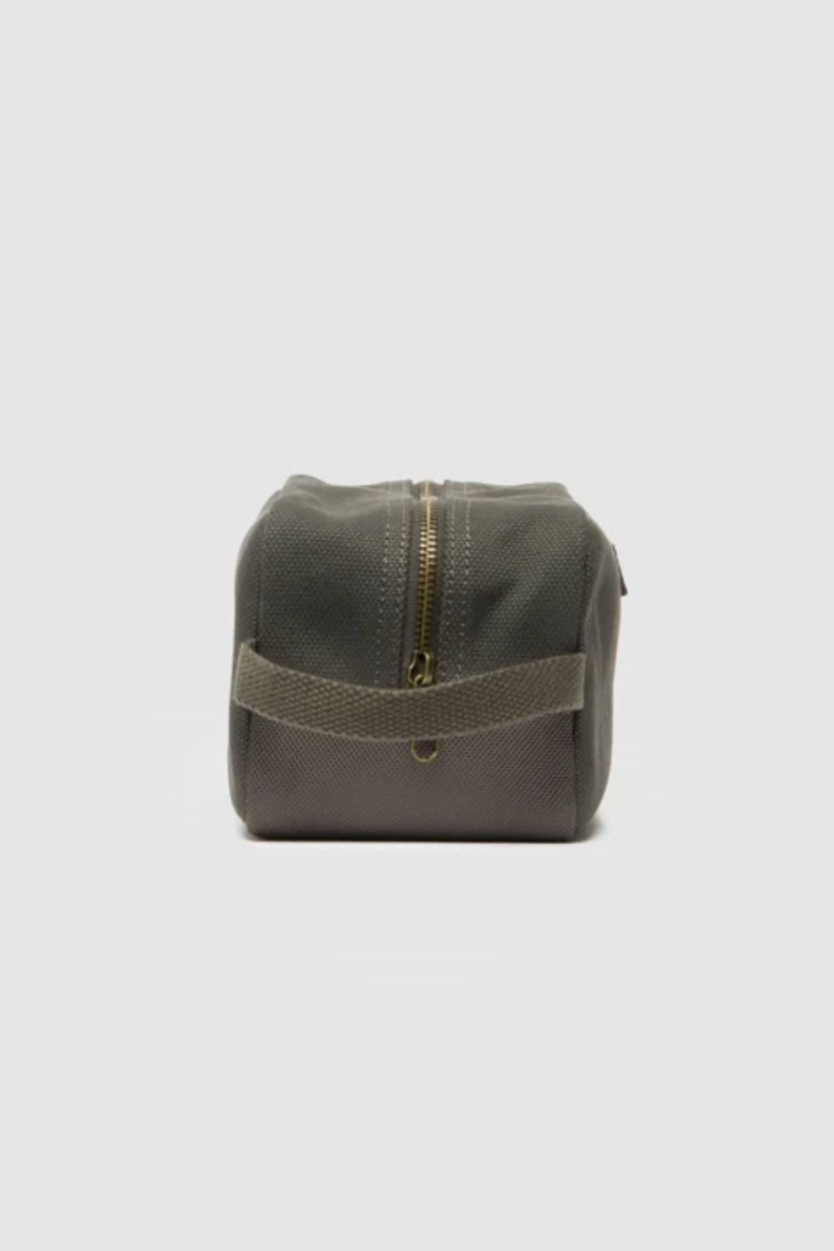 The Rodd & Gunn Ponsonby Wash Bag, made from durable olive green cotton canvas, features a side handle and gold top zipper, shown against a plain white background.