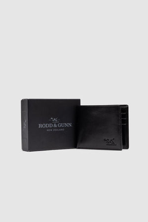 The Rodd & Gunn Wakefield Bi-Fold Wallet in black Italian leather stands open next to its matching branded box, set against a plain light gray background.