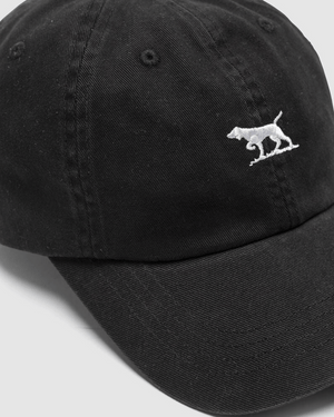 The Rodd & Gunn Gunn Cap is a black cotton twill baseball cap with a small white embroidered dog logo on the front. It features an adjustable strap for a perfect fit and is pictured at an angle against a light gray background.