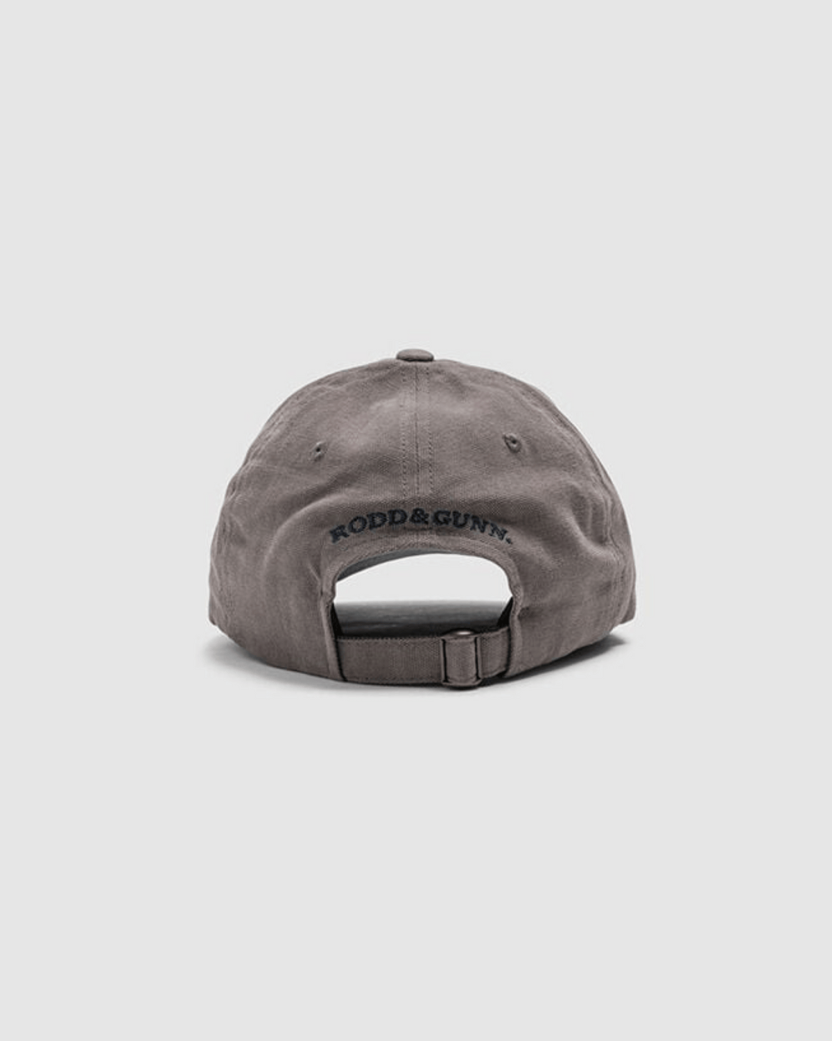 The Rodd & Gunn Signature Cap is a gray cotton twill baseball cap, seen from the back, featuring an adjustable strap and "RODD & GUNN" embroidered in black above the opening.