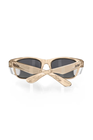 The SafeStyle Classics Champagne Frame Polarised Lens sunglasses are shown from the back with crossed arms, featuring dark UV400 polarised lenses and "bella" inscribed on the upper left side of the frame.
