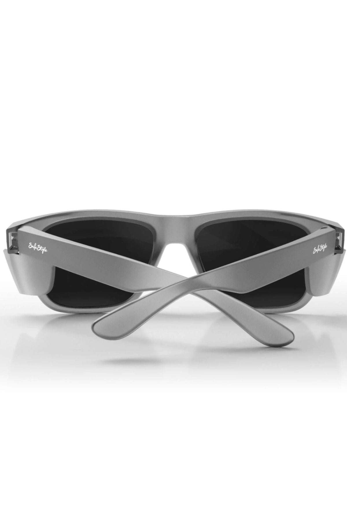 The Safestyle Fusions XL sunglasses feature a matte graphite rectangular frame with polarised dark lenses, shown from the back with crossed arms on a white surface—stylish eyewear offering UV protection.