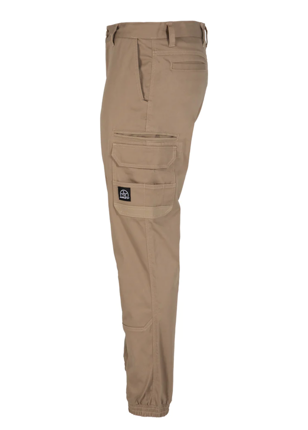 Side view of the UNIT Demolition Cargo Cuffed Pant in beige, made from durable stretch fabric with cargo pockets and a black patch. Features include an elasticated ankle cuff and waist belt loops, providing both style and functionality.