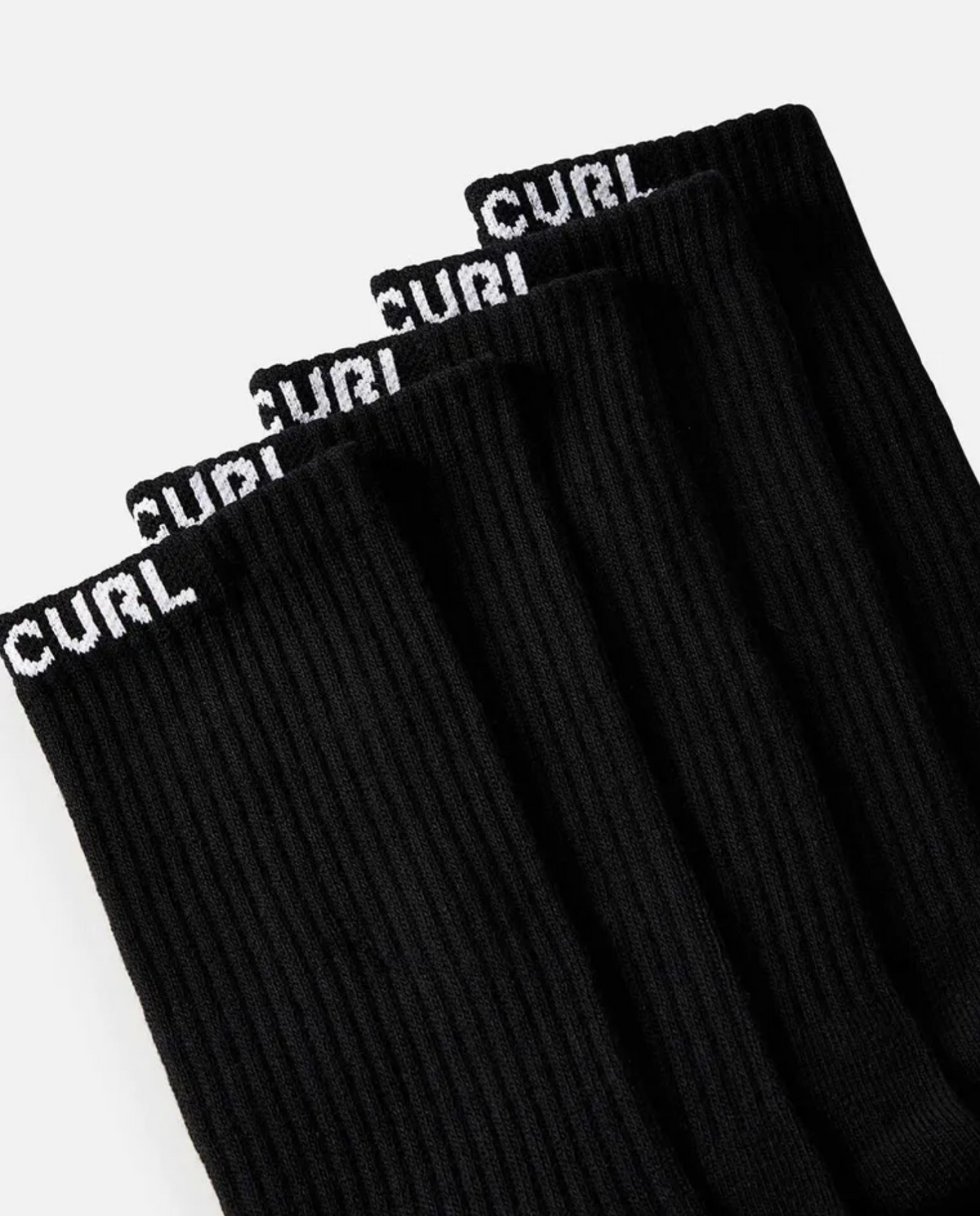 Close-up of Rip Curl Brand Crew Sock 5 Pack, showcasing five black ribbed crew socks, each featuring the word "CURL" in white capital letters at the top. Designed for optimal arch support, these socks are neatly arranged in a row with their tops perfectly aligned against a plain white background.