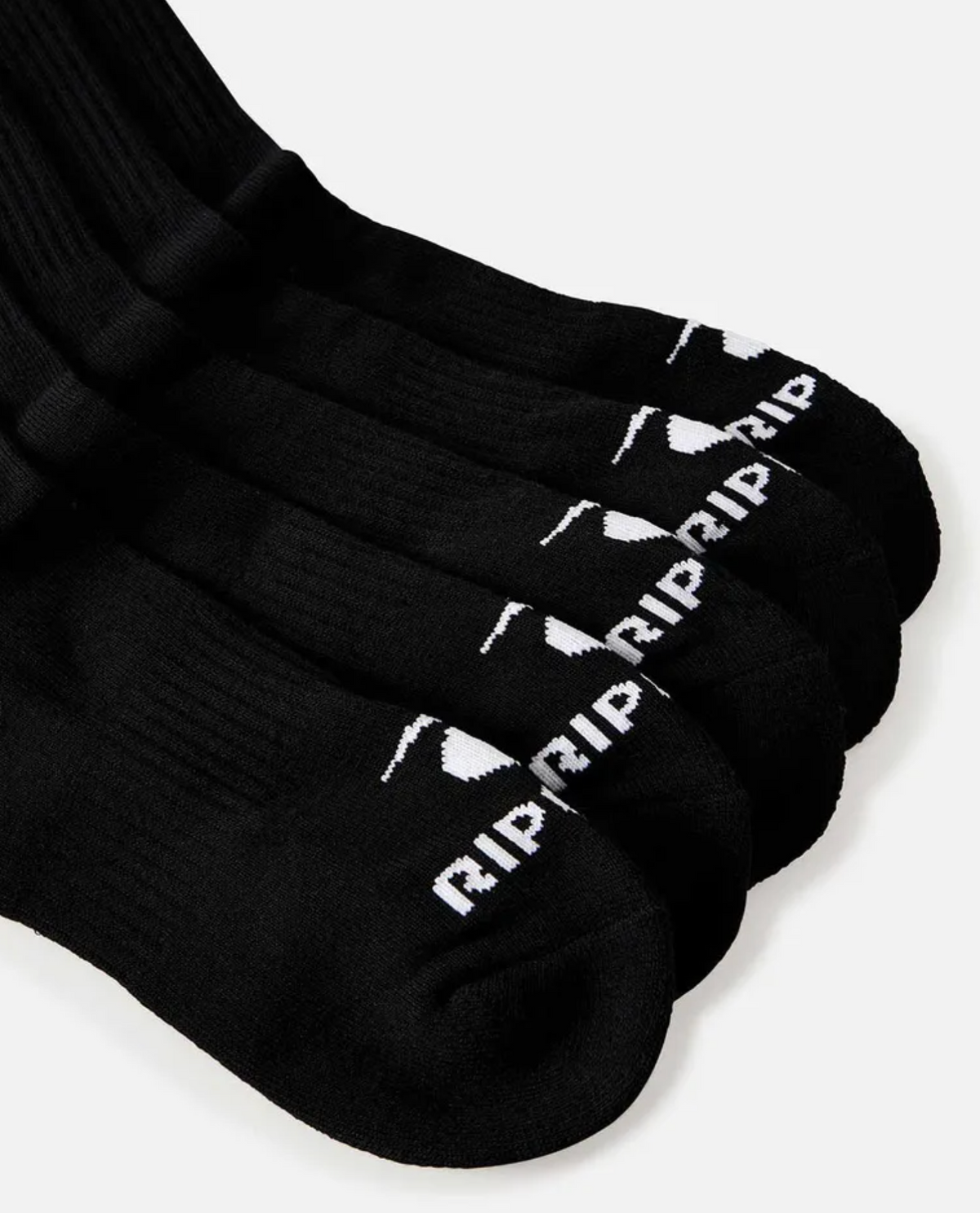 A set of five black crew socks from the Rip Curl Brand Crew Sock 5 Pack is laid out in a slightly fanned arrangement. Each sock, branded with Rip Curl, features white text and a small design on the toe area. They also provide arch support for added comfort. The background is a plain white surface.