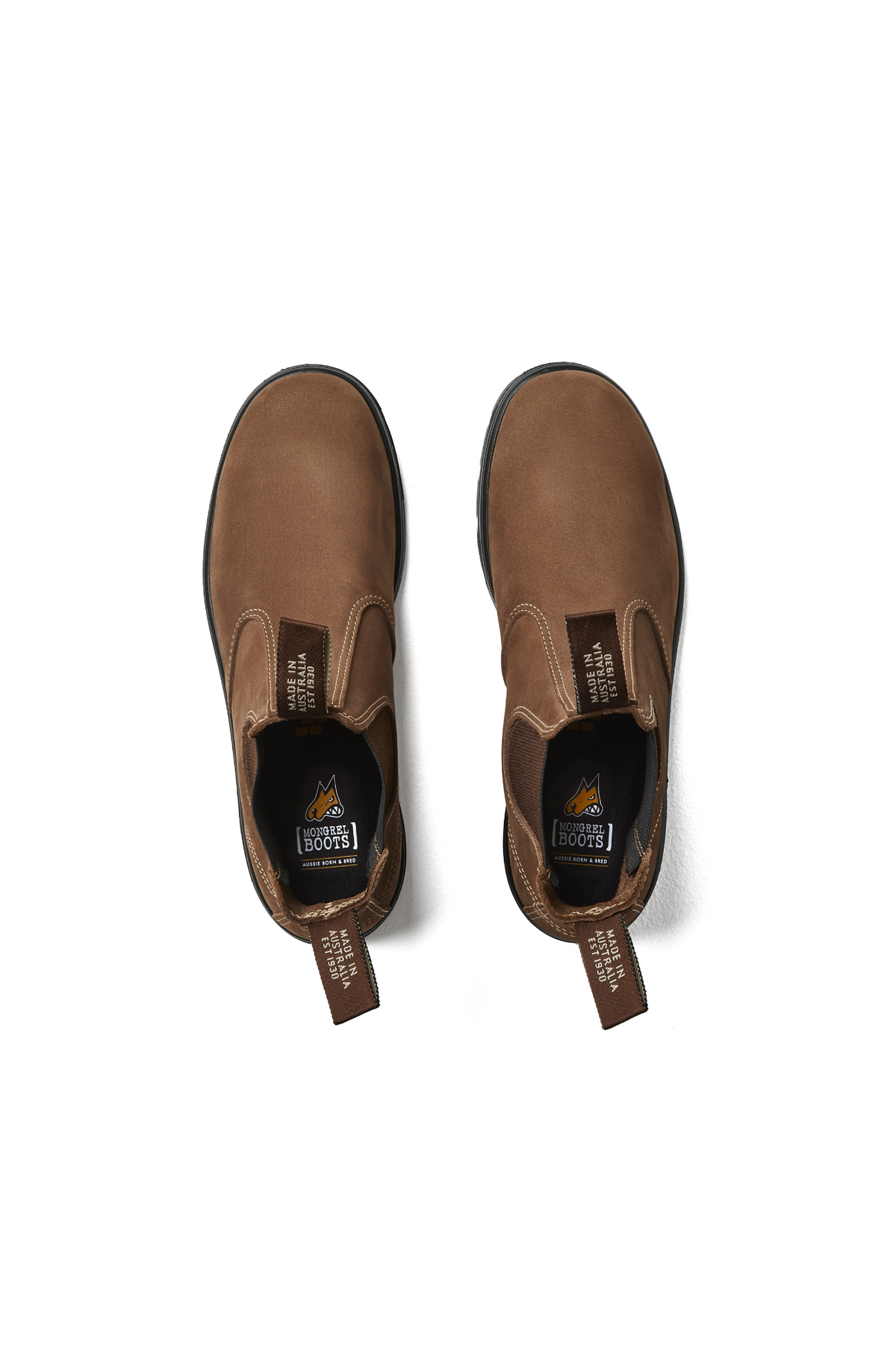 A pair of brown Mongrel K9 Elastic Sided Boot K91070 work boots with oil and fat resistant black soles and "Steel Blue Boots" pull tabs, viewed from above on a white background.