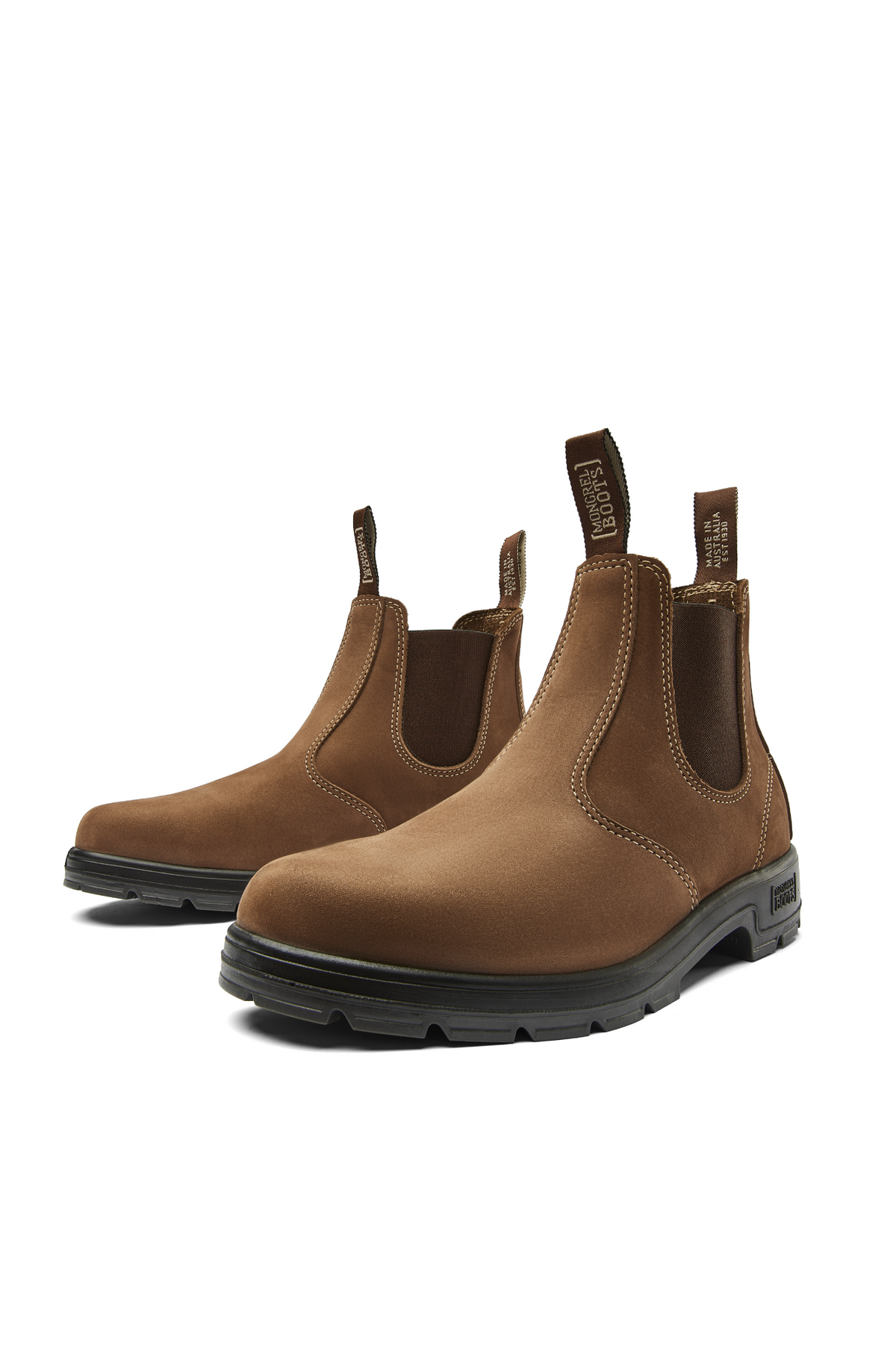 The Mongrel K9 Elastic Sided Boot K91070 is a pair of brown Chelsea boots with black oil and fat resistant soles, elastic side panels, and front and back pull tabs, shown on a white background.