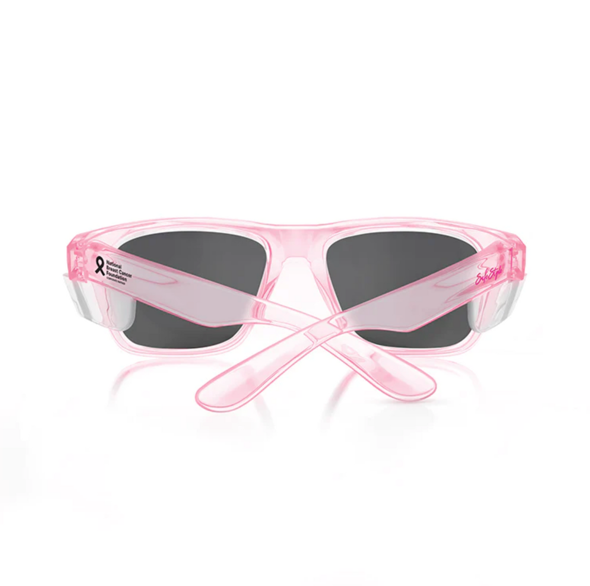 The SafeStyle Fusions Pink Frame Polarised Lens sunglasses feature transparent pink polycarbonate frames, black polarised lenses, and a left arm adorned with a small black ribbon plus "Breast Cancer Awareness Month" text. Shown from the back.