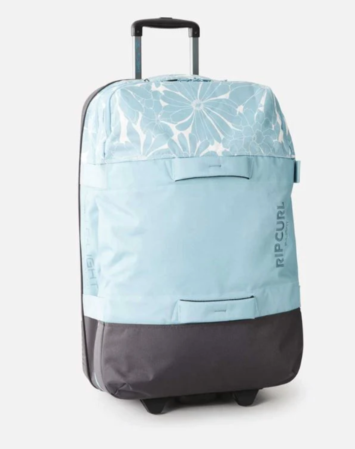 The Rip Curl F-Light Global 110L Sessions Travel Bag is a light blue and gray rolling suitcase with a floral pattern, made from recycled polyester, featuring an extendable handle and two wheels, shown on a white background.