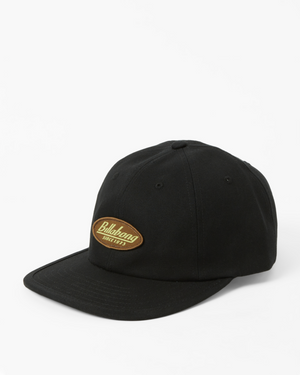 The Billabong Bong Days Strapback Cap is a stylish black cap with a curved brim and an adjustable webbing buckle closure. A brown oval patch on the front displays "Billabong" and "Since 73" in vibrant yellow on a crisp white background.