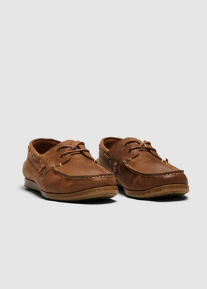 The Rodd & Gunn Gordons Bay Boat Shoe features a leather upper, visible stitching, and brown laces, complemented by a light brown rubber outsole. Displayed against a plain light gray background, these shoes are crafted in brown leather.