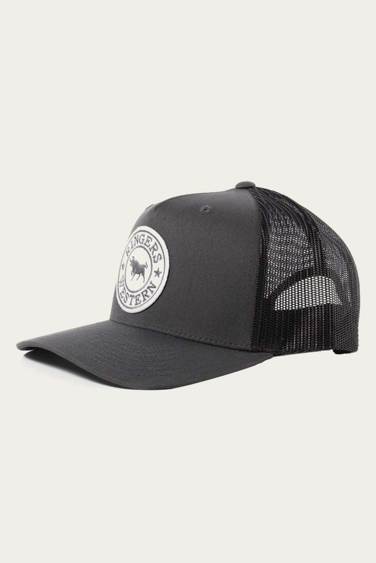 The Ringers Western Signature Bull Trucker Cap features a round white patch with bull design, a breathable mesh back, and an adjustable strap for comfort.