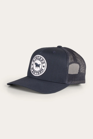 The Ringers Western Signature Bull Trucker Cap is navy blue with a cotton twill front, mesh back, and a round white "Ringers Western" patch featuring a bull silhouette on the front.