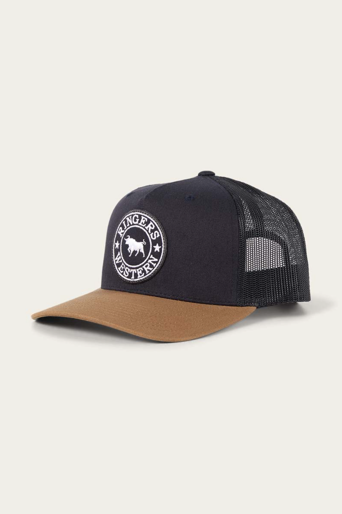 The Ringers Western Signature Bull Trucker Cap features a black mesh back, a brown cotton twill brim, and a white circular "Ringers Western" bull logo on the front. Displayed on a plain light background.