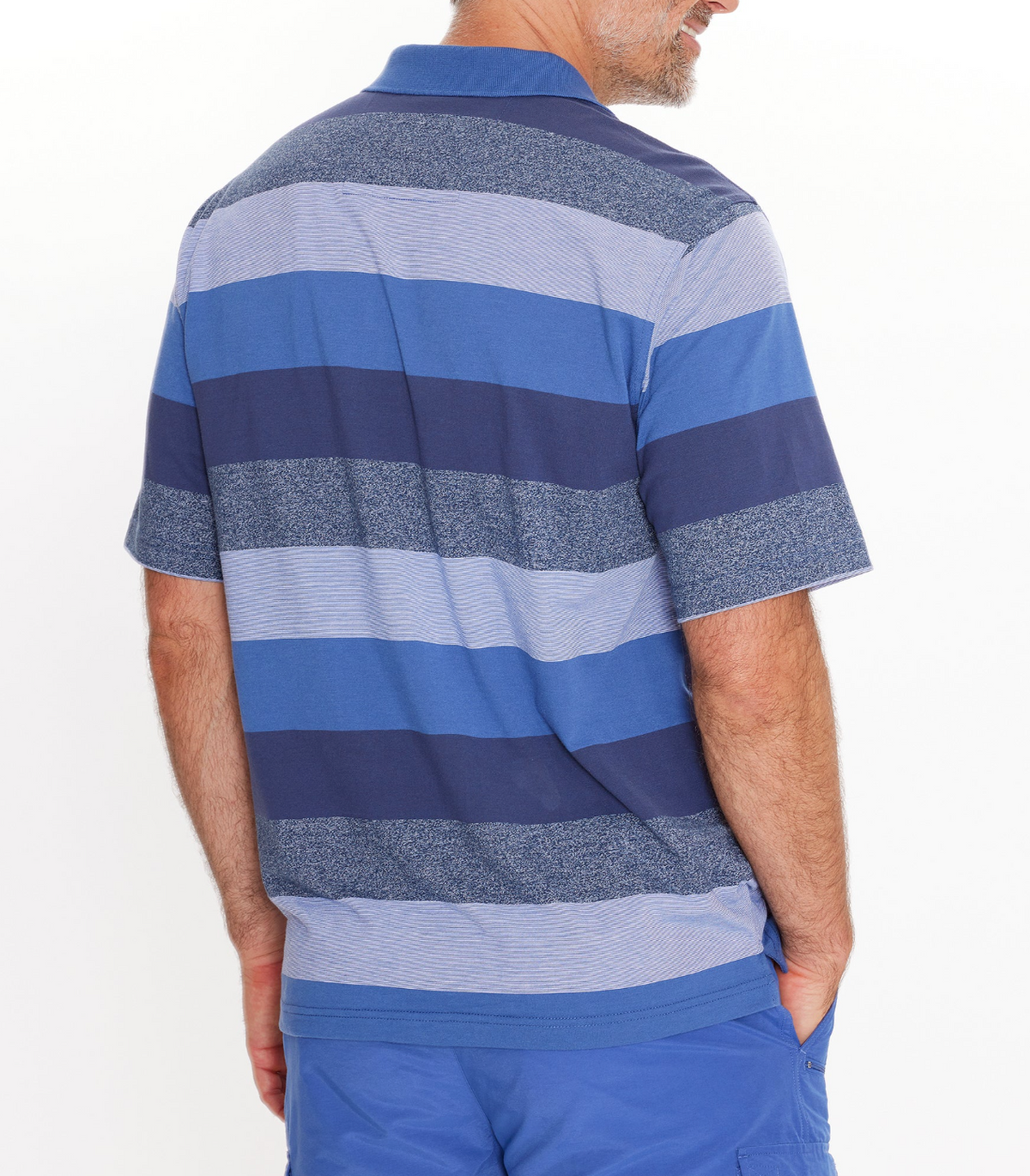 A man wearing a regular fit, short-sleeve Breakaway Neon Kinnersly Polo with blue and gray stripes and a rib knit collar, paired with blue shorts, stands with one hand in his pocket against a white background.
