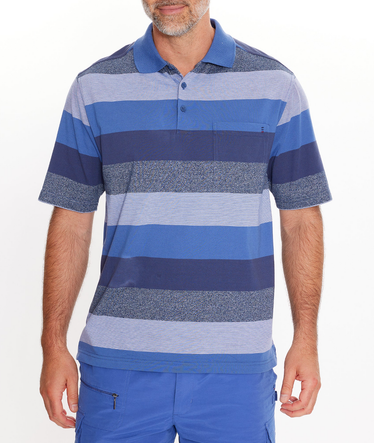 A man in a Breakaway Neon Kinnersly Polo with a rib knit collar, chest pocket, and blue striped design, paired with blue shorts, stands against a white background. His face is partially visible.