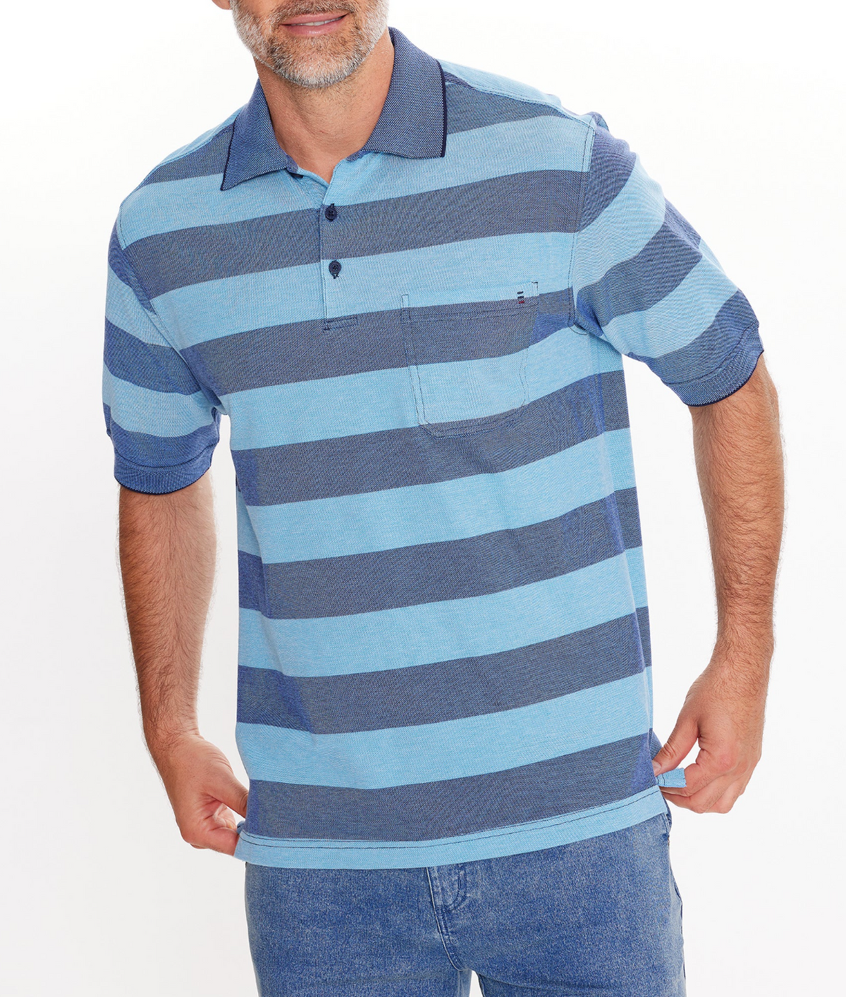 A man showcases the Breakaway Syd Cotton Pique Polo, a regular fit blue and dark blue striped shirt with a pocket. Made of 100% cotton, it features short sleeves, a buttoned collar, and complements his blue jeans. The background is simple white.