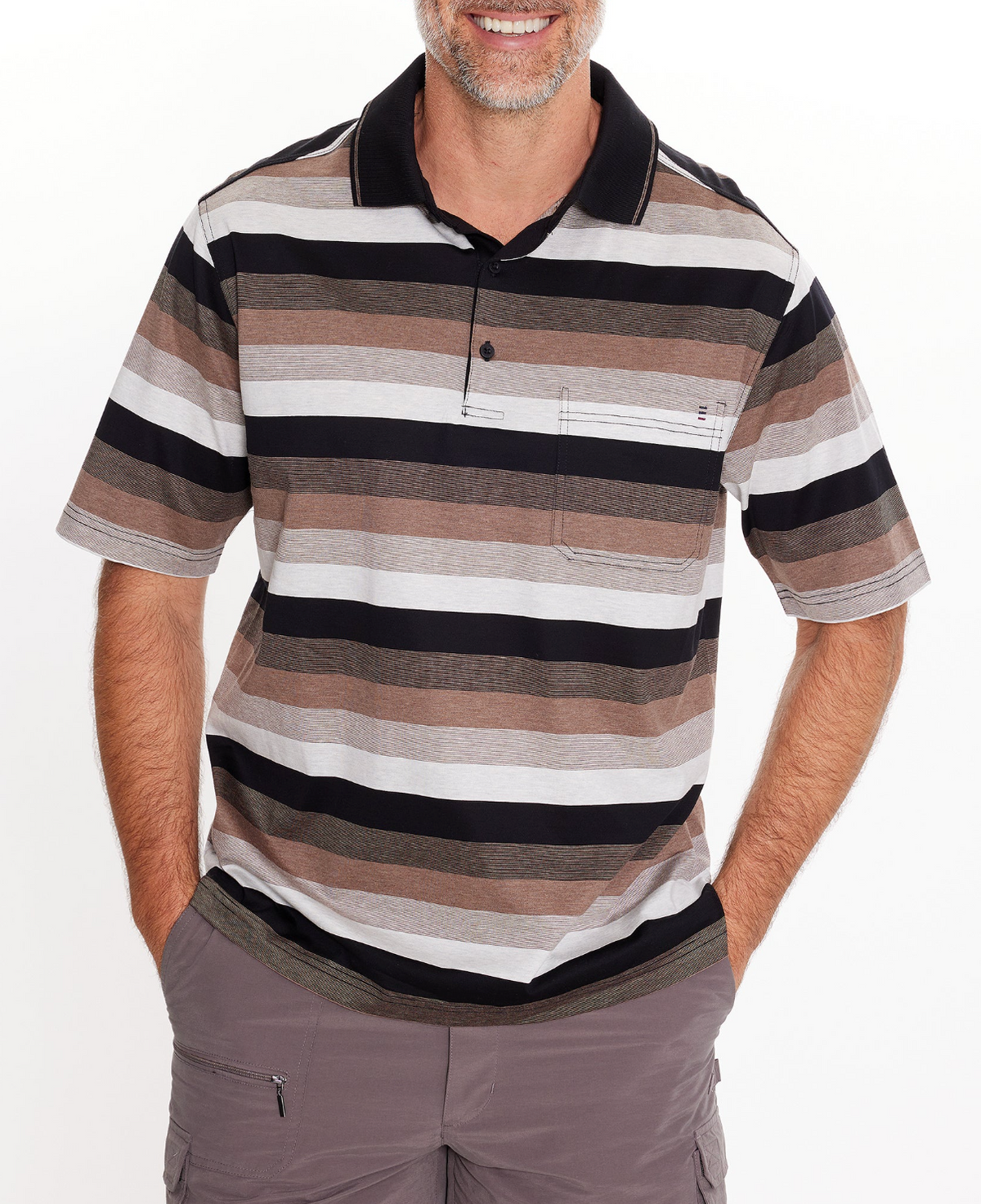 A man, smiling with hands in his gray pants pockets, models the Breakaway Ked Mercerised Polo—a casual short-sleeve shirt with horizontal brown, black, and gray stripes—shown from chest up.