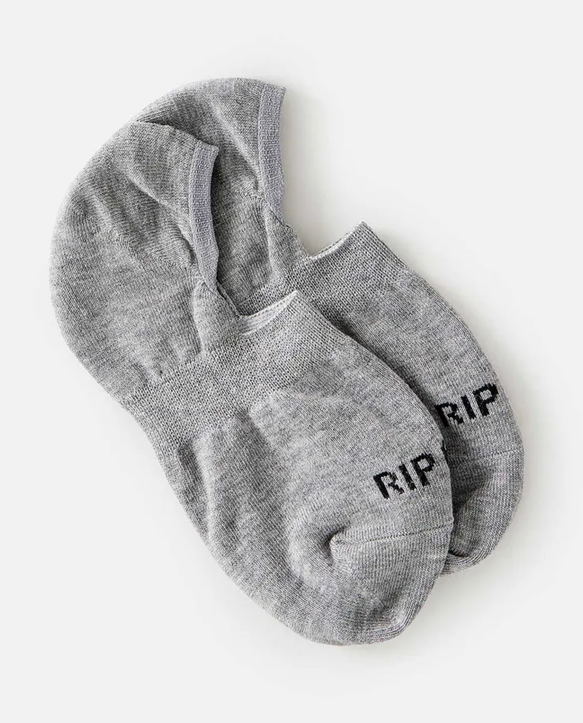 A pair of gray Rip Curl Women's Invisible Socks displays dark "RIP" lettering on the toes, set against a plain white background, featuring an inner heel silicon grip and slightly overlapping.