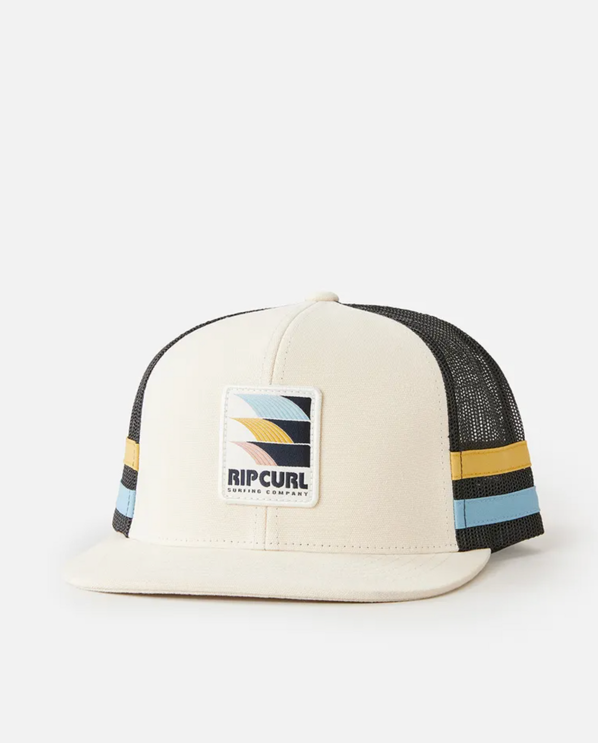 The Rip Curl Surf Revival Trucker is a beige and black snapback hat featuring a flat brim, mesh back, blue, yellow, and black side stripes, and a front embroidered patch logo with a retro wave design.