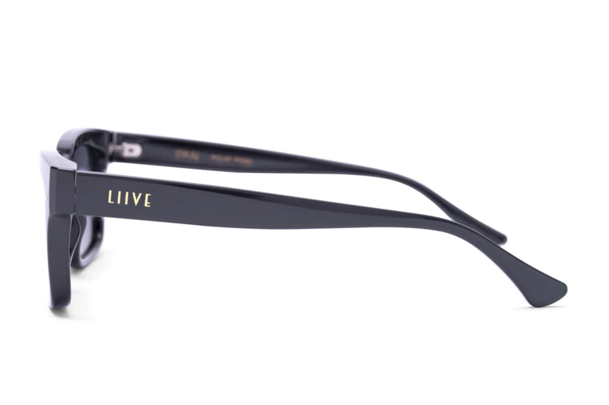 Side view of black Liive Dan Polar sunglasses with "LIIIVE" in gold on the arm. Crafted with polycarbonate lenses, these sunglasses boast a sleek, glossy finish and slightly curved arms for both style and UV protection.