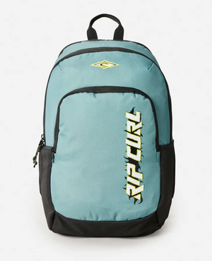 The Rip Curl Ozone 2025 School 30L Backpack in teal and black is made from recycled polyester, featuring a large front pocket, side pockets, top handle, and bold yellow vertical "RIP CURL" logo—ideal for school. Shown on a white background.