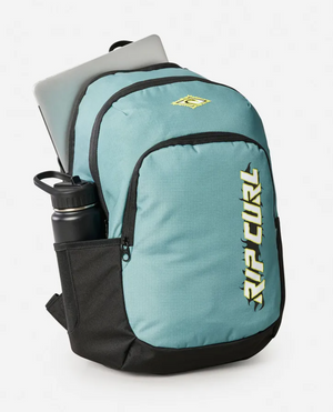The Rip Curl Ozone 2025 School 30L Backpack in teal and black, made from recycled polyester, is shown with a laptop partially visible in the main compartment and a water bottle in the side pocket, set against a plain background.