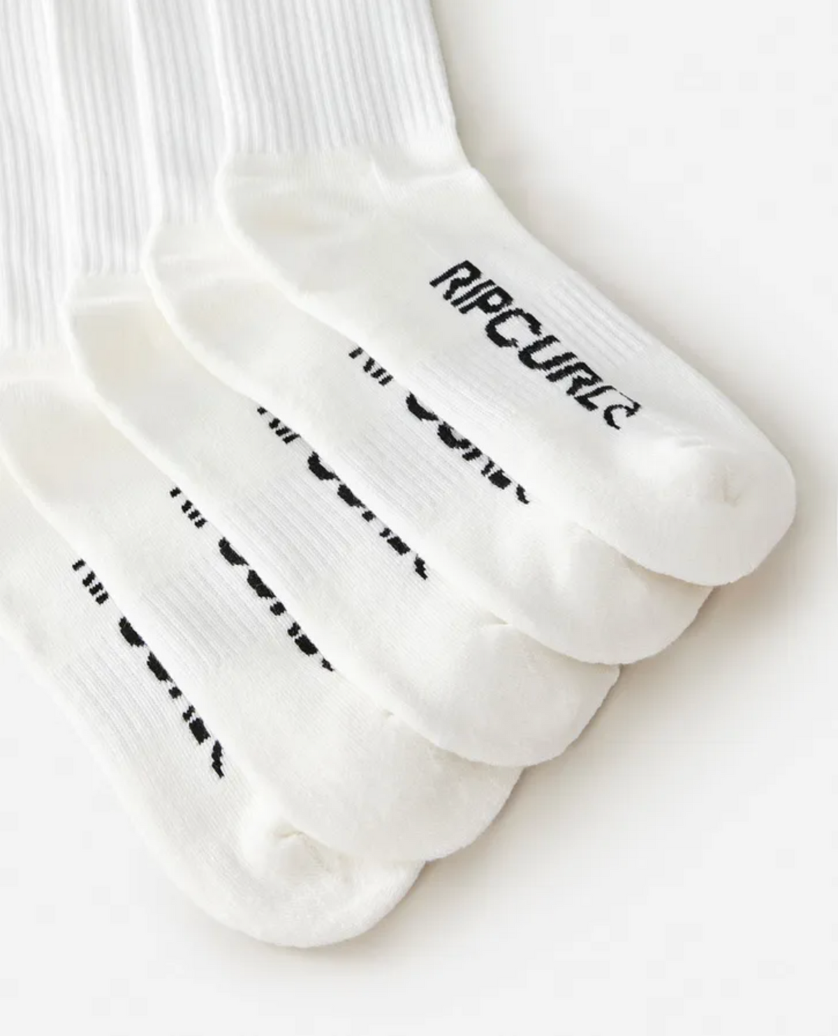 Five pairs of white ribbed Rip Curl School Crew Socks are stacked diagonally, each with "RIP CURL" in black on the toes. The socks feature arch support and a terry footbed for comfort, shown on a plain white background.