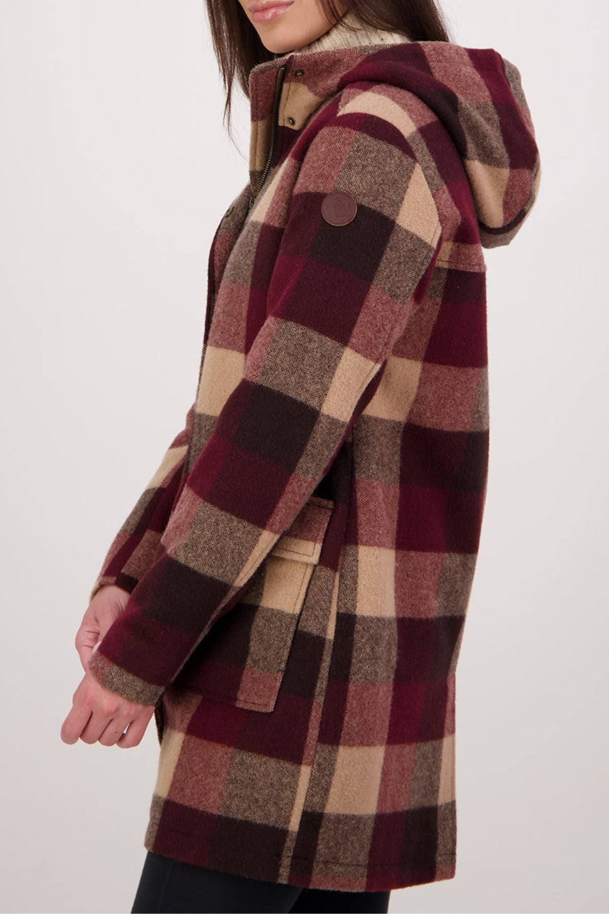 A person shown from the side wears the Swanndri Annmore V2 Wool Overcoat, featuring a large burgundy, brown, and beige checkered pattern and a hood, crafted from New Zealand wool, against a plain background.