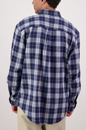A person is shown from the back wearing a blue and white plaid Swanndri Barn Shirt and beige pants against a plain light background—ideal for those wanting classic heritage style and easy winter layering.