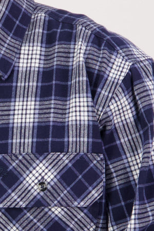 Close-up of the Swanndri Barn Shirt in blue and white plaid, showing its heritage style, front chest pocket, button, and part of the collar—ideal for layering in winter.