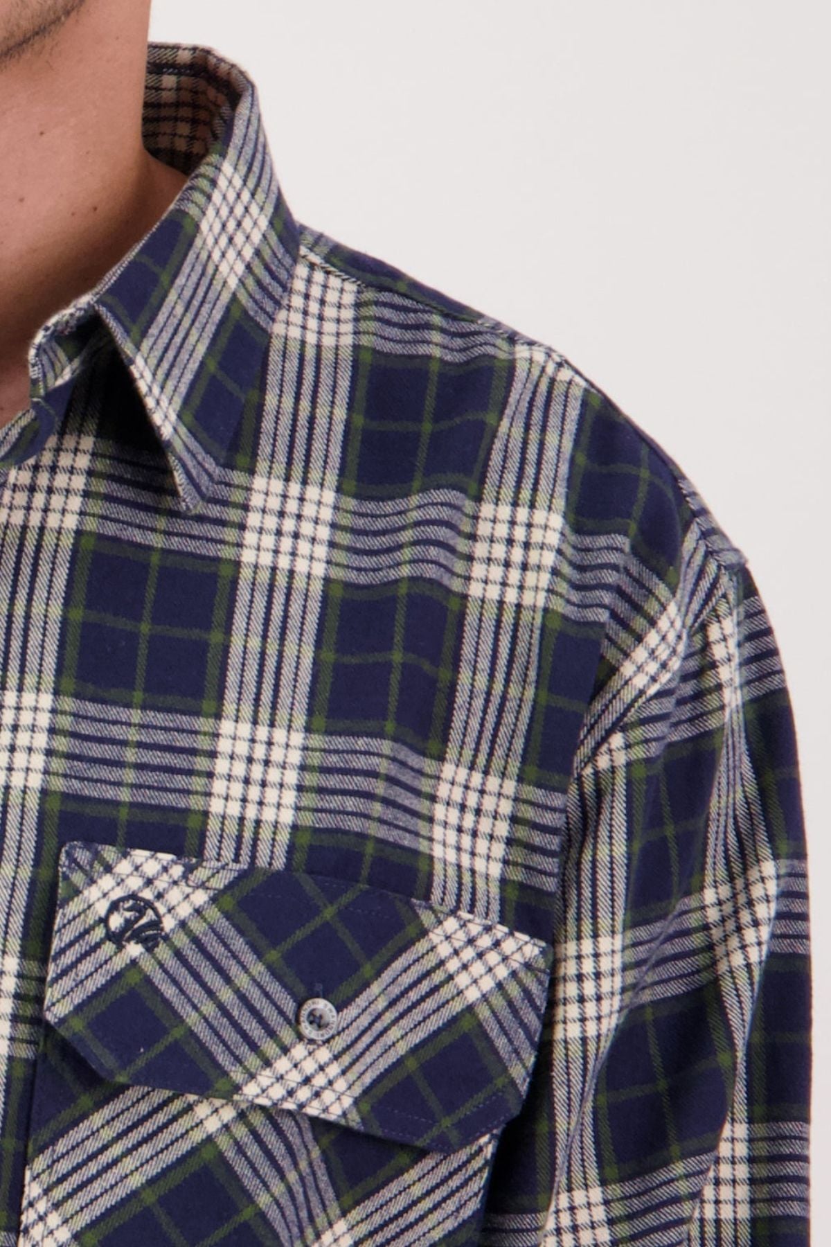 Close-up of a person in a Swanndri Barn Shirt featuring blue, green, and white plaid—showing only the lower face, neck, shoulder, and chest. This heritage-style shirt is perfect for winter layering.