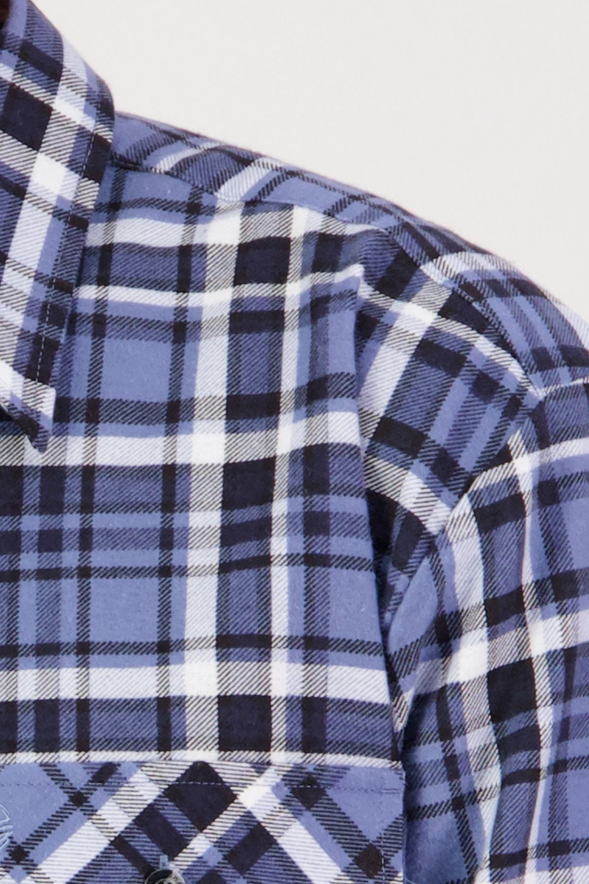 Close-up of the Swanndri Egmont Flannelette Twin Pack: a blue, black, and white plaid shirt featuring the collar, shoulder, and chest pocket—showcasing a cozy classic long sleeve style.