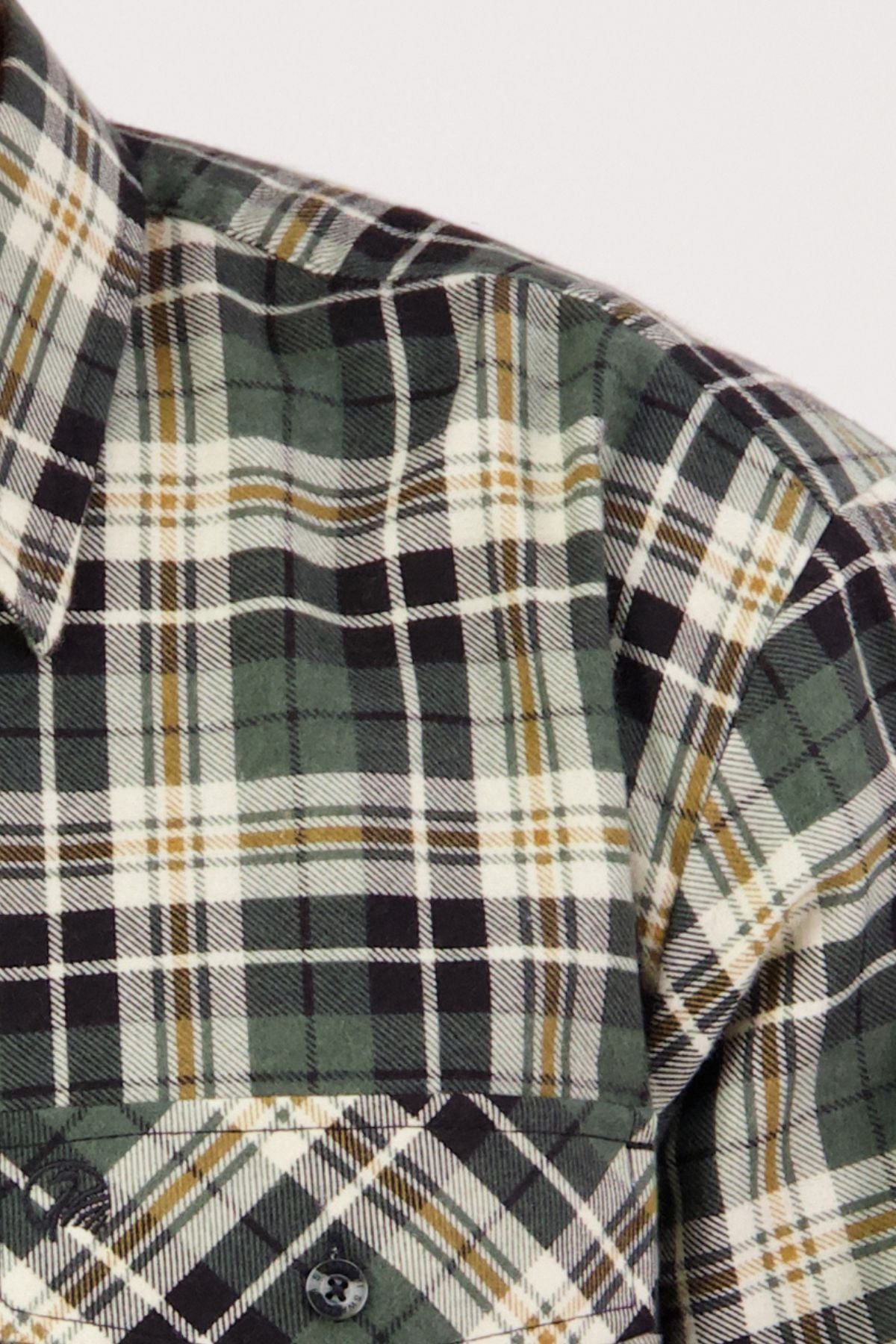 Close-up of the Swanndri Egmont Flannelette Twin Pack: green, black, and white plaid long sleeve shirt with a buttoned chest pocket and collar, made from durable flannelette fabric with multicolored intersecting lines.