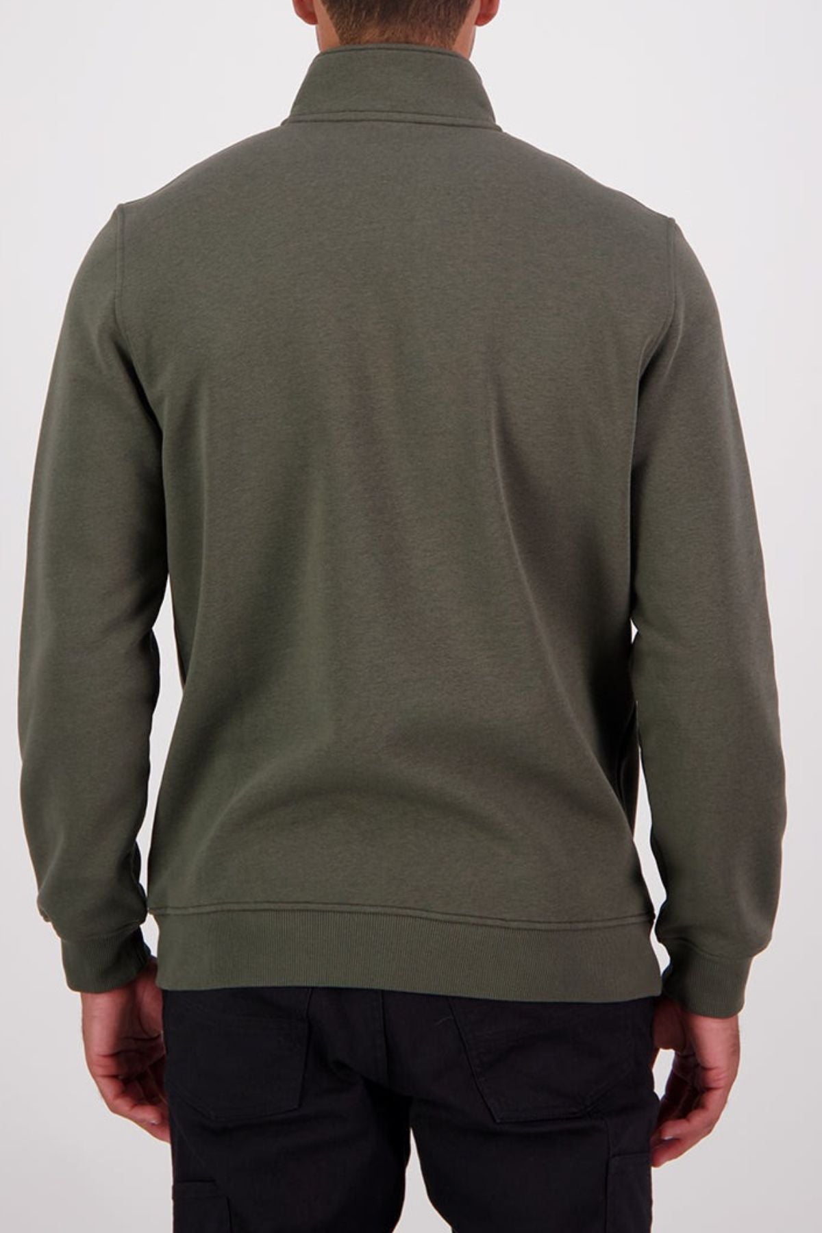 Someone stands against a plain light background, facing away from the camera, wearing an olive green Swanndri Fundamentals Quarter Zip made with recycled polyester and black pants.