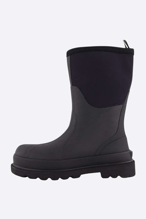 The Grubs Fenline Mid Work Boot is a black work boot with a rubber sole and neoprene-like upper, featuring a pull tab for easy wear. It offers superior grip, perfect for wet or muddy conditions.