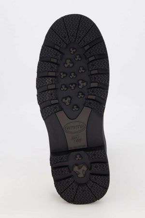 The image features the underside of a Grubs Fenline Mid Work Boot sole, showcasing black rubber with diverse tread patterns, including hexagonal shapes and large geometric designs for superior grip. The brand "Artex" and model number are embossed for maximum safety.