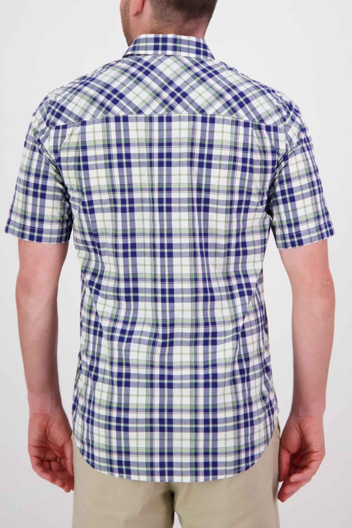 A person wearing the Swanndri Herbert Short Sleeve Shirt, a tailored fit in blue, green, and white plaid cotton, stands with their back to the camera. They are also dressed in beige pants against a plain white background.