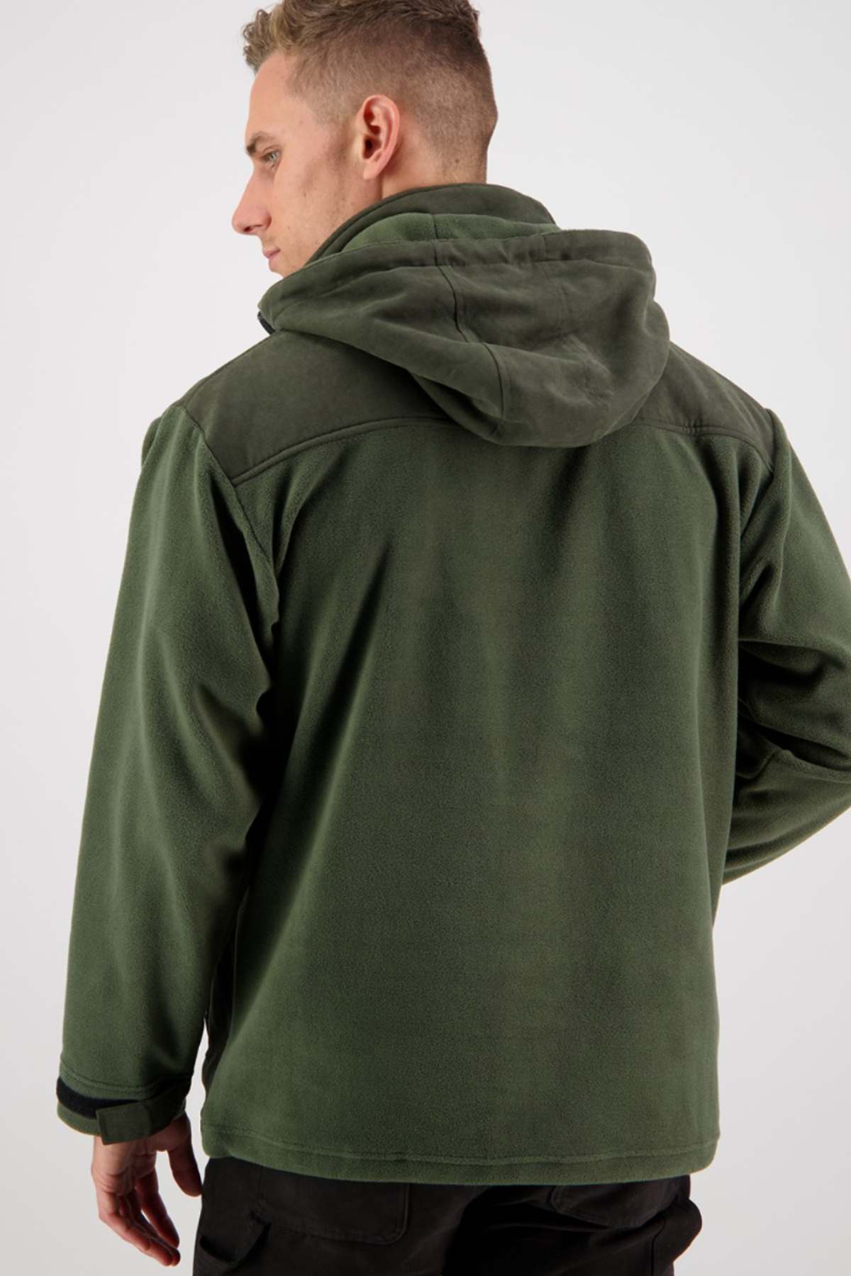 A man with short hair is turned slightly to the right, facing away from the camera. He is wearing a Swanndri High Rock Fleece Pullover with a hood and fleece lining. The background is plain and white.