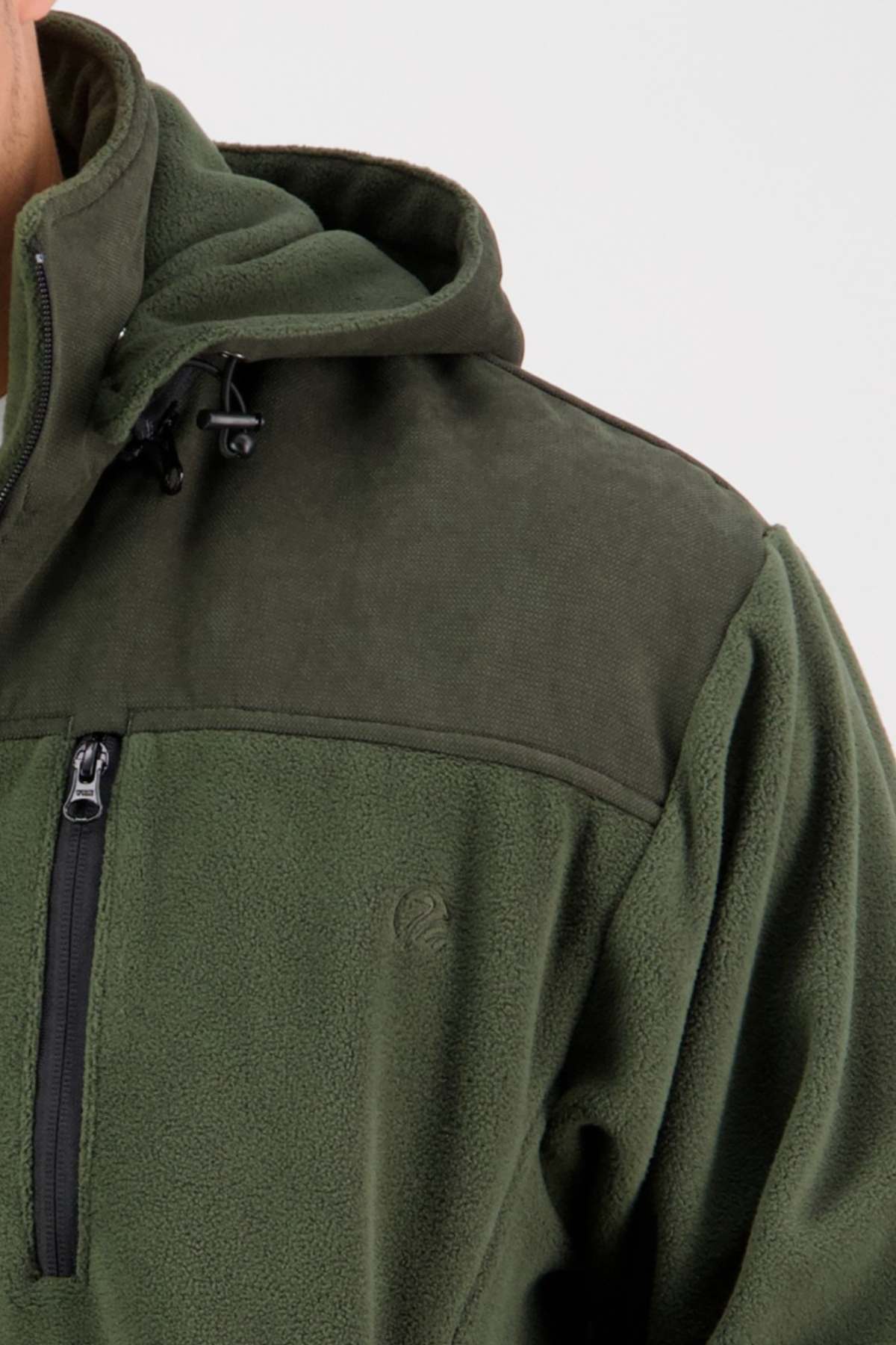 Close-up image of a person wearing the Swanndri High Rock Fleece Pullover. The green fleece jacket includes a hood and showcases a dark green shoulder panel with waterproof fabric and a zippered chest pocket. This partial view emphasizes the texture and details of the fleece lining.