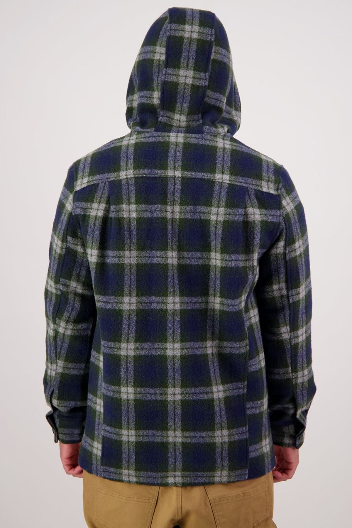A person is shown from the back against a plain light background, wearing a blue and green plaid Swanndri Hudson Hoodie and tan pants.