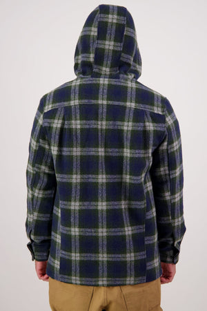 A person is shown from the back against a plain light background, wearing a blue and green plaid Swanndri Hudson Hoodie and tan pants.