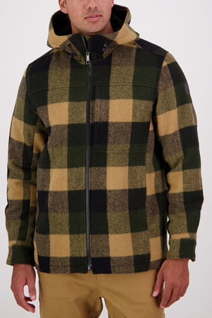 A man wearing a Swanndri Hudson Hoodie made from comfortable New Zealand wool with a large black, green, and tan plaid pattern stands with his arms relaxed by his sides.
