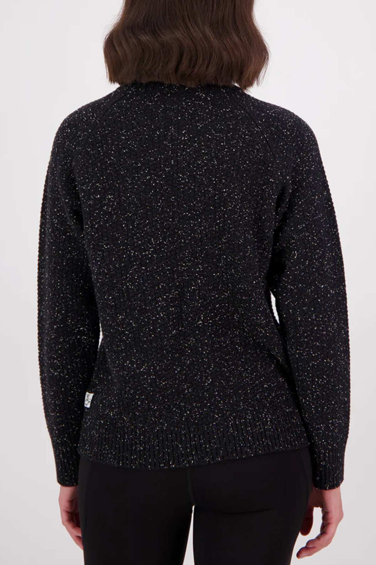 A person with shoulder-length brown hair is shown from the back, wearing the Swanndri Lyttelton v2 Roll Neck Knit in black and black pants against a plain light background.