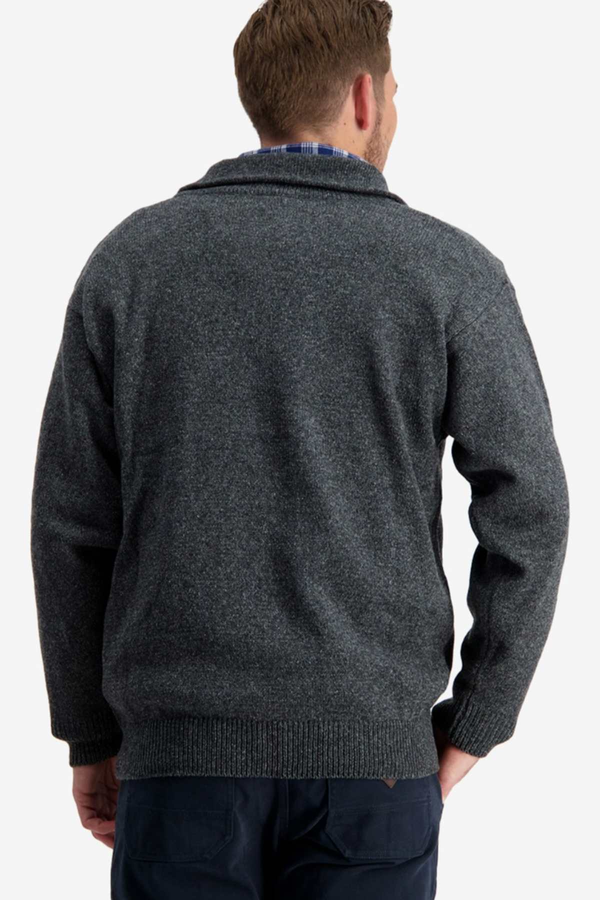 A man with short hair, seen from behind, is wearing the Swanndri Mariner Zip Neck Sweater in dark gray. This knit sweater features a shawl collar and a textured pattern, enhanced by a modern half zip front. He pairs the wool-polyester blend sweater with dark pants, all set against a plain white background.