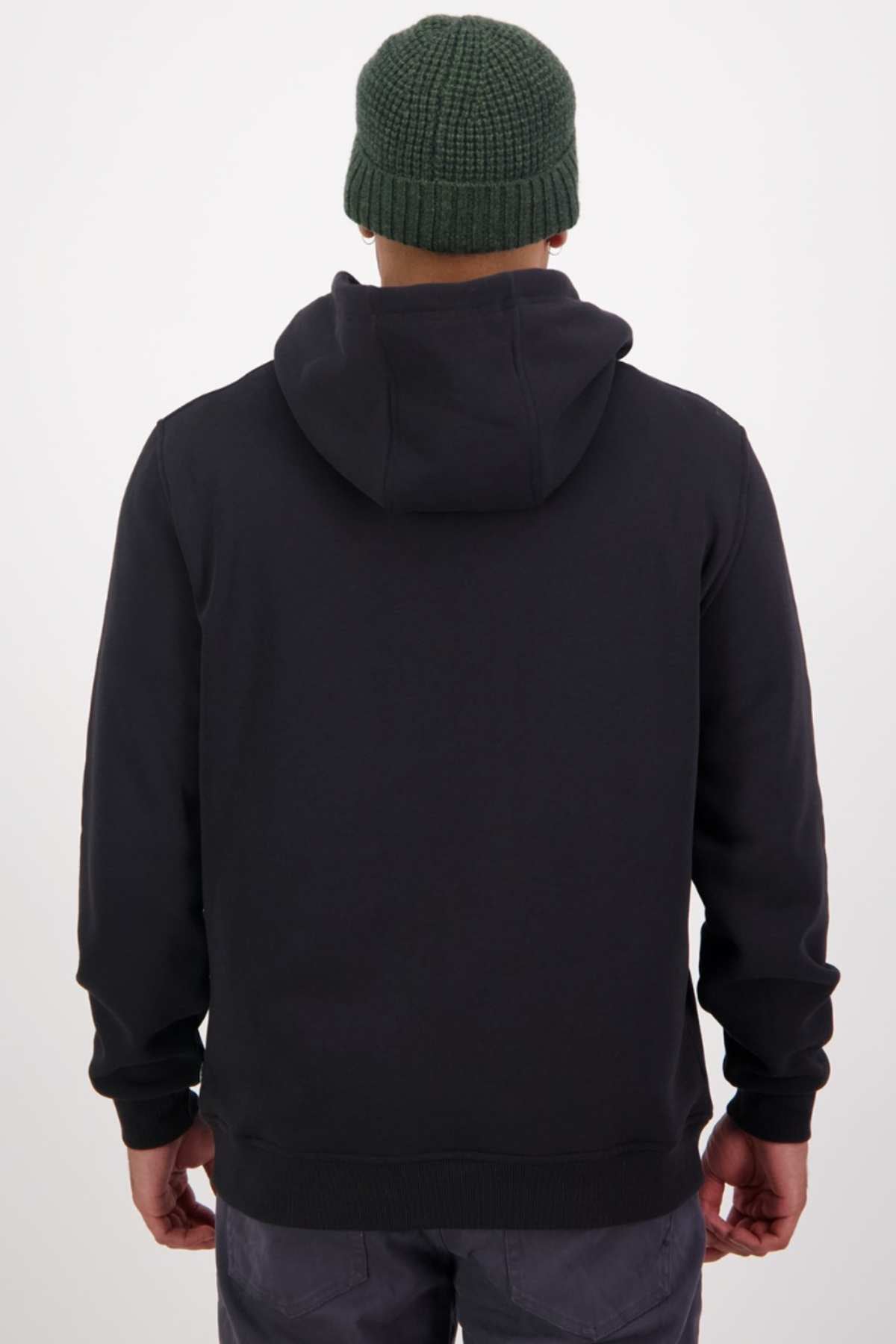 A person wearing a dark hoodie and green knit beanie is shown from the back. The hoodie, named Swanndri Original V2, inspired by the classic Swanndri print, features a hood and contrasts against the neutral background.